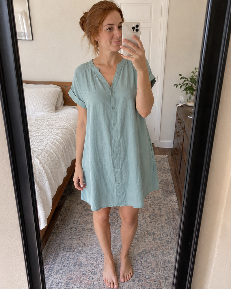 Woman wearing the Odette shirt dress in sage green, photographed in a bedroom mirror