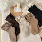 Maud knit socks in all five colours, laid flat with the ribbed cuffs folded