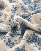 Fabric close-up of the blue toile print on cream, showing the matte crepe weave