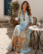 Seated at a café table with a coffee, the dress falling open over the knee and gathering on the ground.