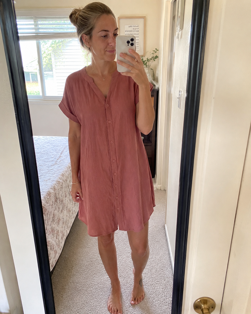 Woman wearing the Odette shirt dress in rose, photographed in a hallway mirror