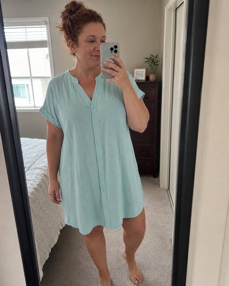 Woman wearing the Odette shirt dress in light mint, photographed in a hallway mirror