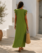 Back view of the Rosalie dress in green, showing the ruffle tracing the V at the back