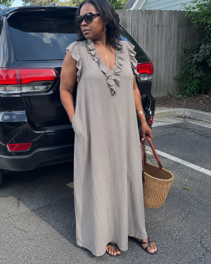 Customer photo: the Rosalie dress in grey worn with flat sandals, hand in the pocket