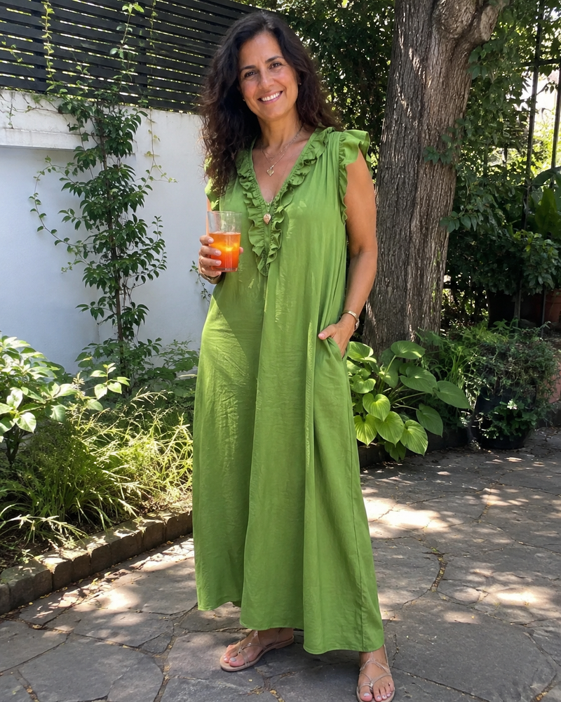 Customer photo: the Rosalie dress in green in a garden, showing the ruffle neckline and the A-line skirt