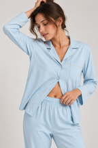 Woman in the Still Nights Modal Sleep Set in Powder Blue, top worn open over the elastic-waist trousers