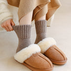 Pulling up the ribbed cuff of a Maud knit sock in taupe
