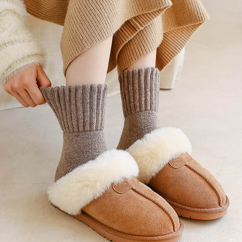 Pulling up the ribbed cuff of a Maud knit sock in taupe